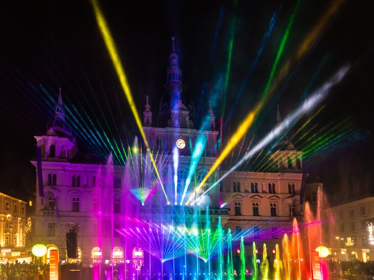Bunte Lichtshow vor dem Grazer Rathaus mit Wasserspielen. | © Graz Tourismus - Harry Schiffer