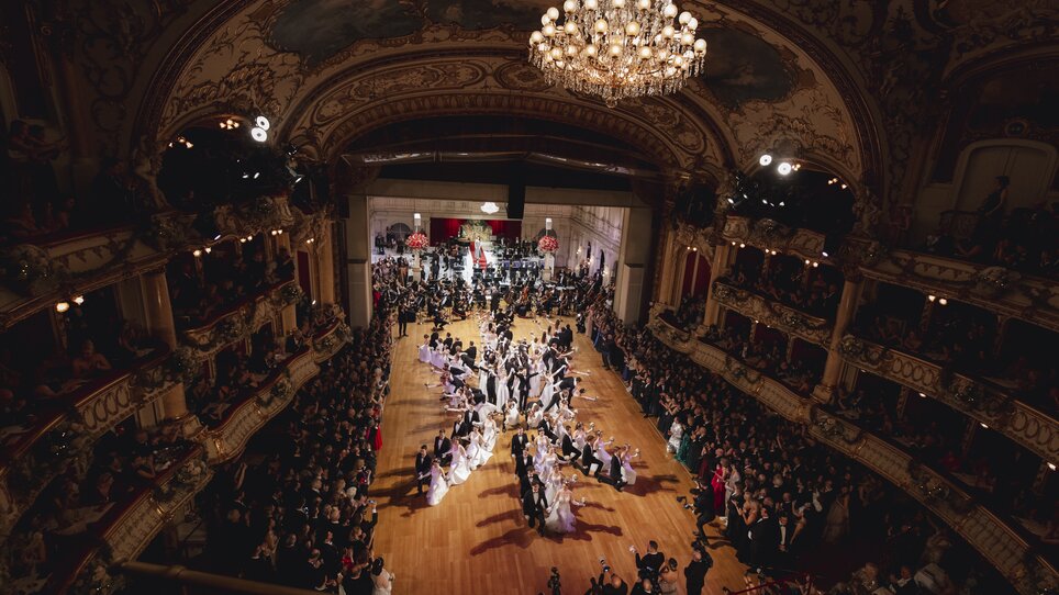 Elegantes Ballevent mit festlich gekleideten Gästen in einem prunkvollen Saal. | © Luef Light
