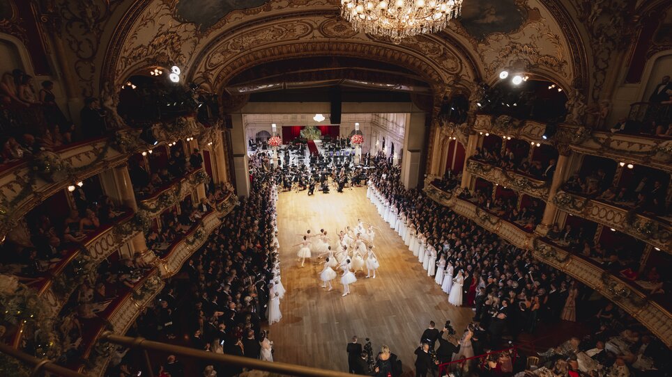 Elegante Opernredoute mit Tänzern und Zuschauern in einem opulenten Saal. | © Luef Light