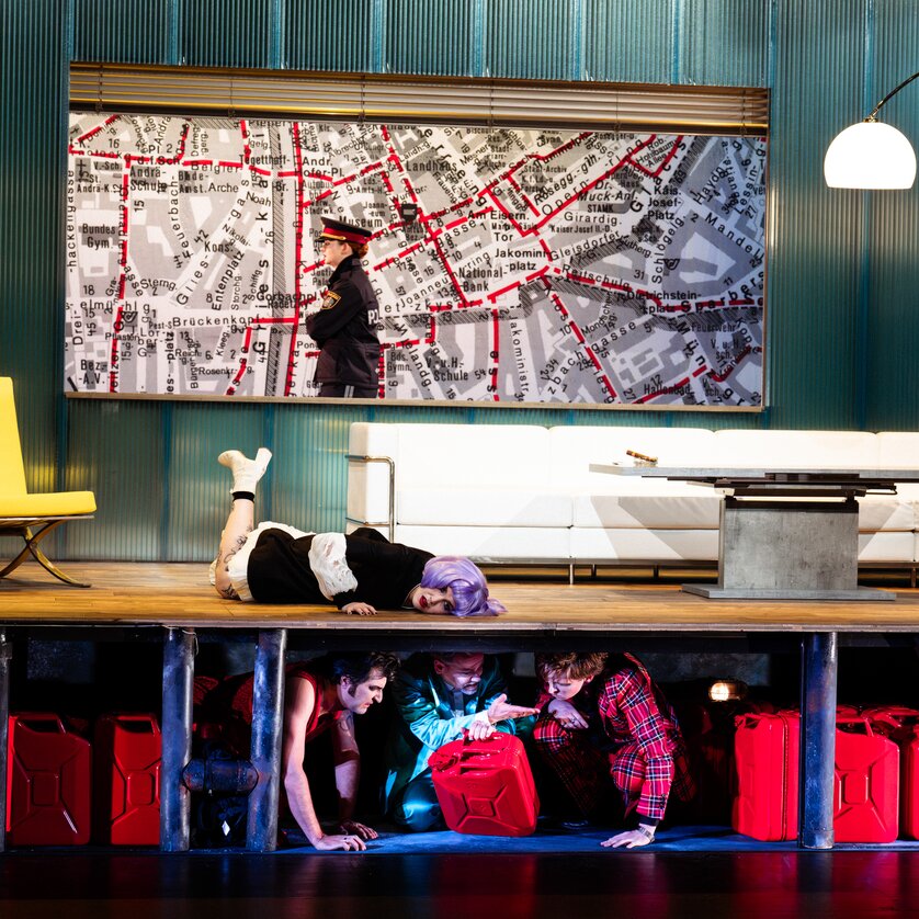 Darstellung einer Theaterszene mit Personen, die sich verstecken.