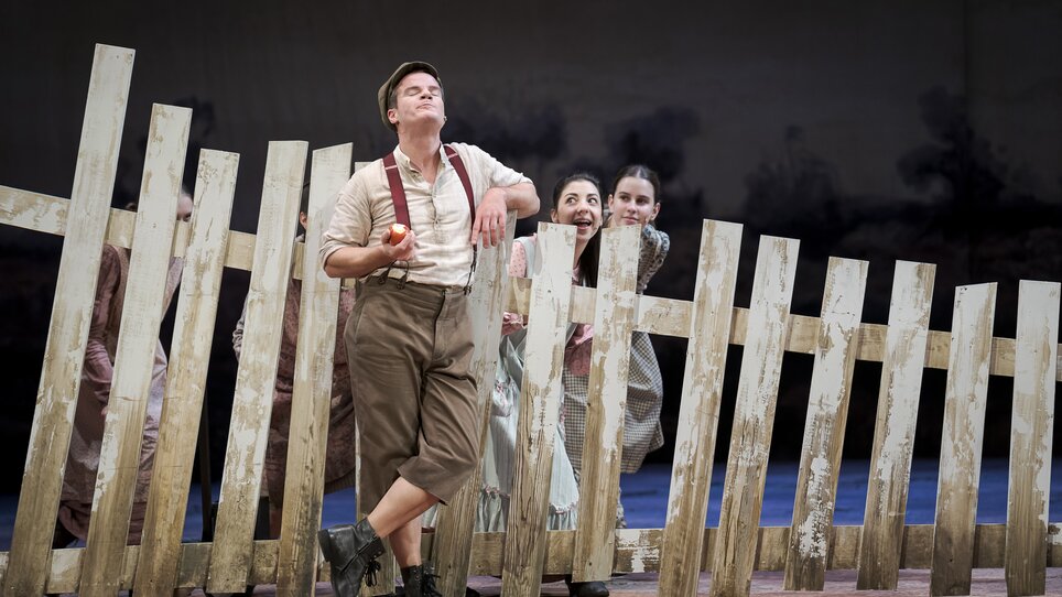Schauspieler posieren hinter einem Zaun auf der Bühne. | © Werner Kemtitsch - Oper Graz
