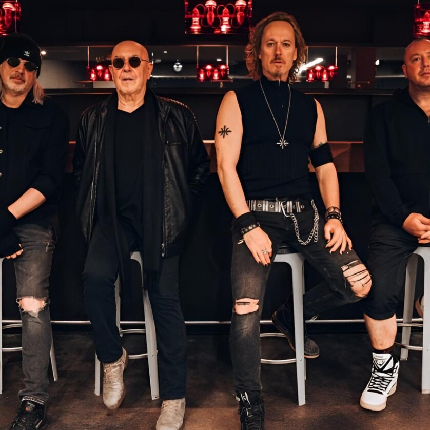 A rock band in modern attire poses together for a photo. | © Lewis Milne