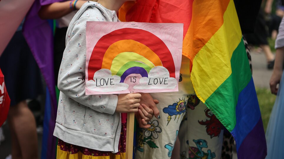 Kind hält ein Schild mit einem Regenbogen und der Aufschrift 'Liebe ist Liebe'. | © Sebastian Neugebauer