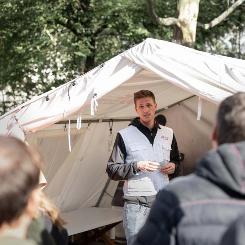 Ausstellung: Ärzte ohne Grenzen hautnah | © Ärzte ohne Grenzen - Ramon Ritter Ein Mitarbeiter von "Ärzte ohne Grenzen" erklärt etwas vor einem Zelt bei einer Informationsveranstaltung. | © Ärzte ohne Grenzen - Ramon Ritter