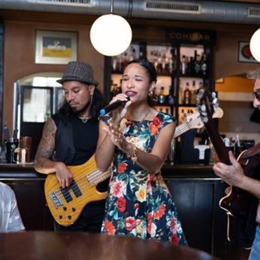 Eine Band spielt in einer Bar, Sängerin und Musiker sind aktiv. | © Marina Ustinova