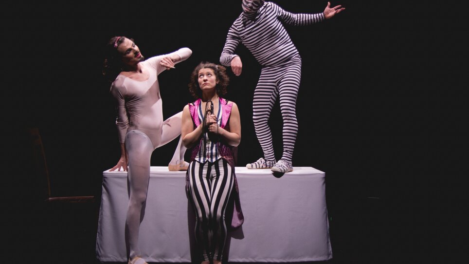 Tre artisti in vari costumi sul palco. | © Christina Berzaczy