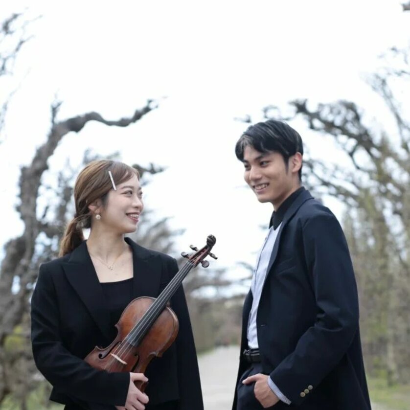 Ein Mädchen mit Geige und ein Junge lächeln im Freien. | © Lisa Fokina