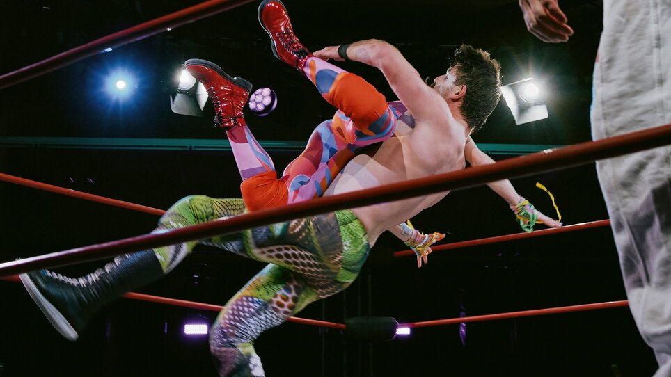 "Paradise Lost: This Fight Is Not a Sign (2026)" by Julian Warner - Ein Wrestler wird beeindruckend in die Luft geworfen. | © Bruno Tenschert