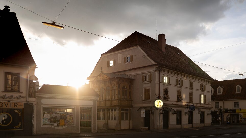 Blick auf ein altes Gebäude mit Fenstern und leuchtendem Schild | © steirischer herbst - Dietmar Reinbacher