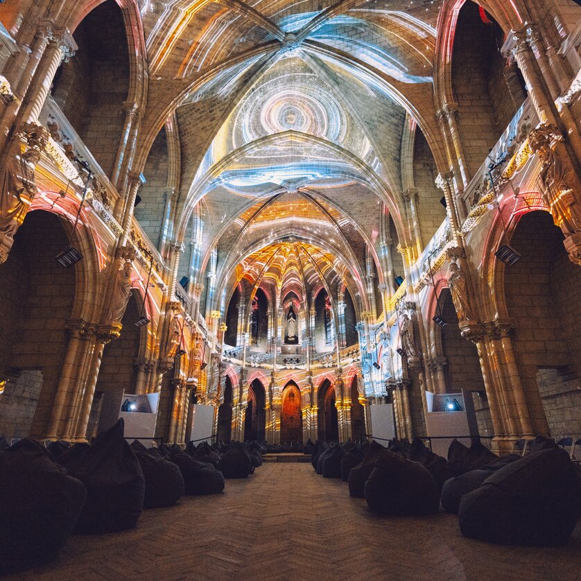 Blick ins Innere einer alten Kirche mit Lichtprojektionen. | © Projektil