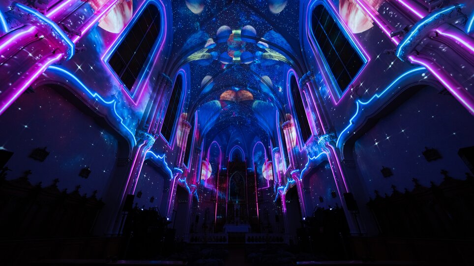 Futuristische Innenansicht einer Kirche mit leuchtenden, farbigen Lichtern. | © Projektil