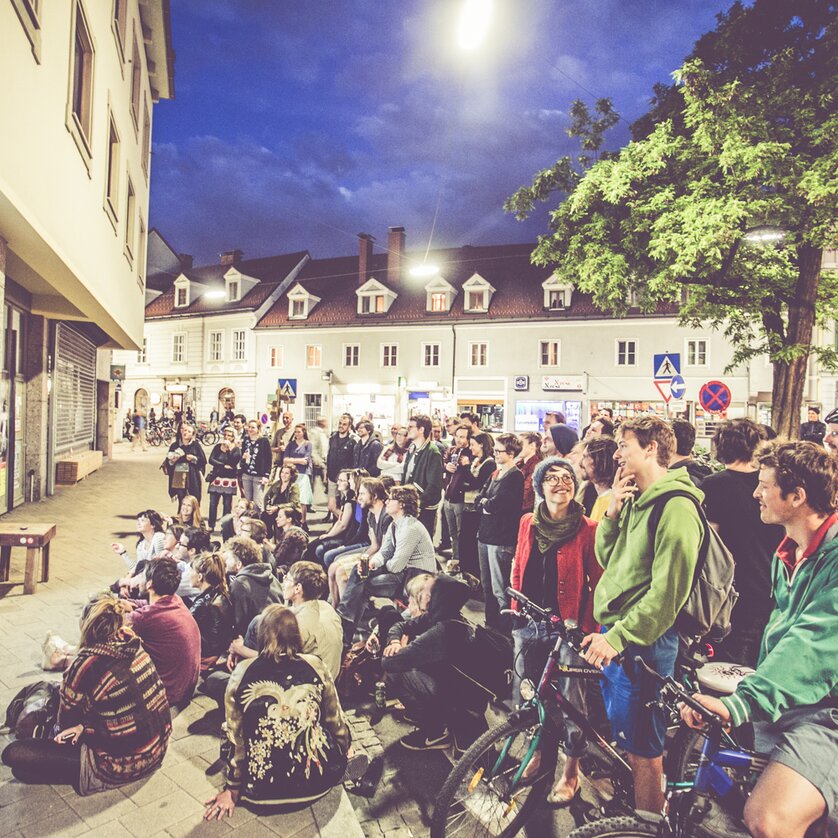 Menschen versammeln sich beim Lendwirbel neugierig vor einem Bildschirm im Freien. | © Lupi Spuma