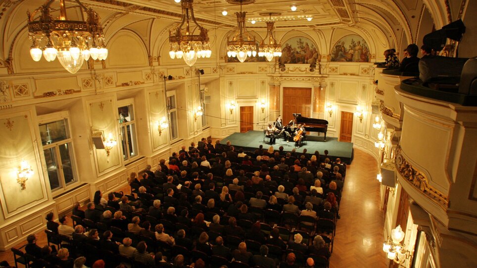Ein gut gefüllter Konzertsaal mit Publikum und Musikern. | © musikabendeGRAZ