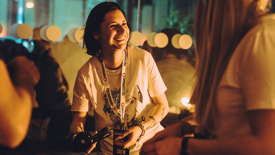 Una DJane sorride e interagisce durante un evento. | © Silent Disco Austria