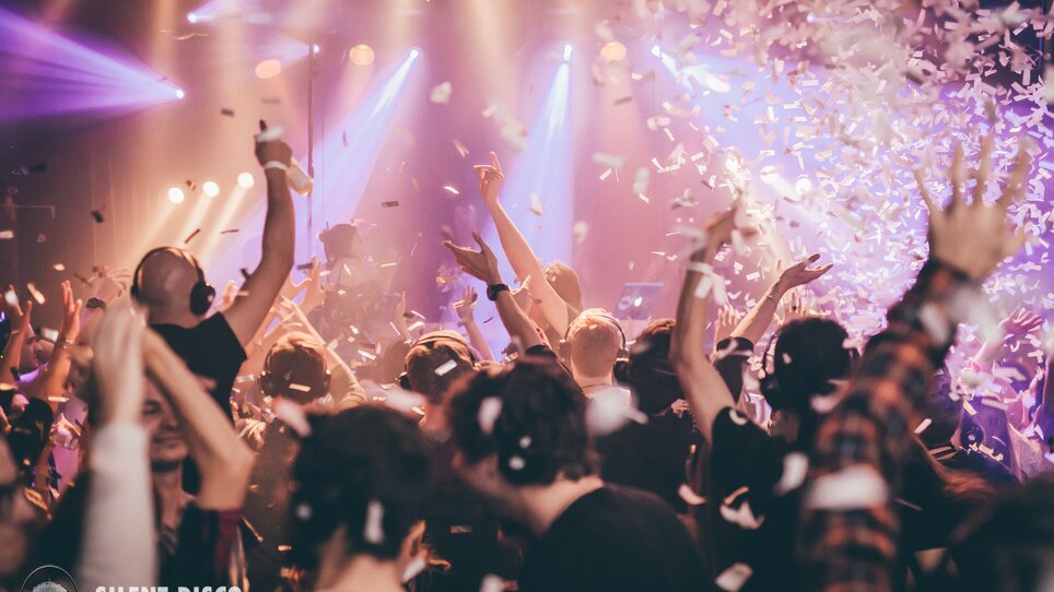 Partecipanti di una silent disco che si divertono con le cuffie e coriandoli. | © Silent Disco Austria