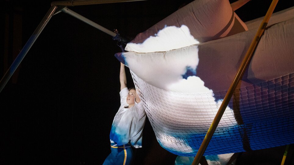 Eine Tänzerin interagiert mit einem großen, wolkenartigen Objekt auf der Bühne. | © Kurt van der Elst
