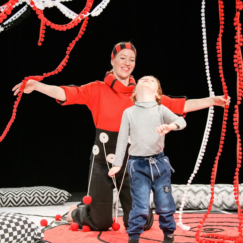 Eine Schauspielerin und ein Kind interagieren in einem bunten Bühnenbild. | © Laura Vansevičienė