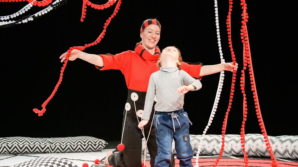 Eine Schauspielerin und ein Kind interagieren in einem bunten Bühnenbild. | © Laura Vansevičienė