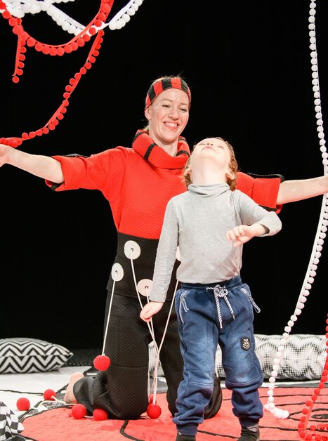 Eine Schauspielerin und ein Kind interagieren in einem bunten Bühnenbild. | © Laura Vansevičienė