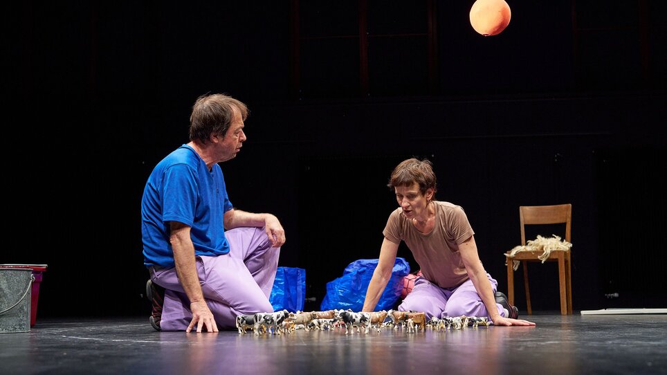 Zwei Darsteller interagieren auf der Bühne mit Requisiten. | © Juerg Fausch