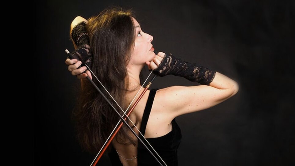 La violinista Lina Tur Bonet posa con il suo strumento su uno sfondo nero. | © Juarez