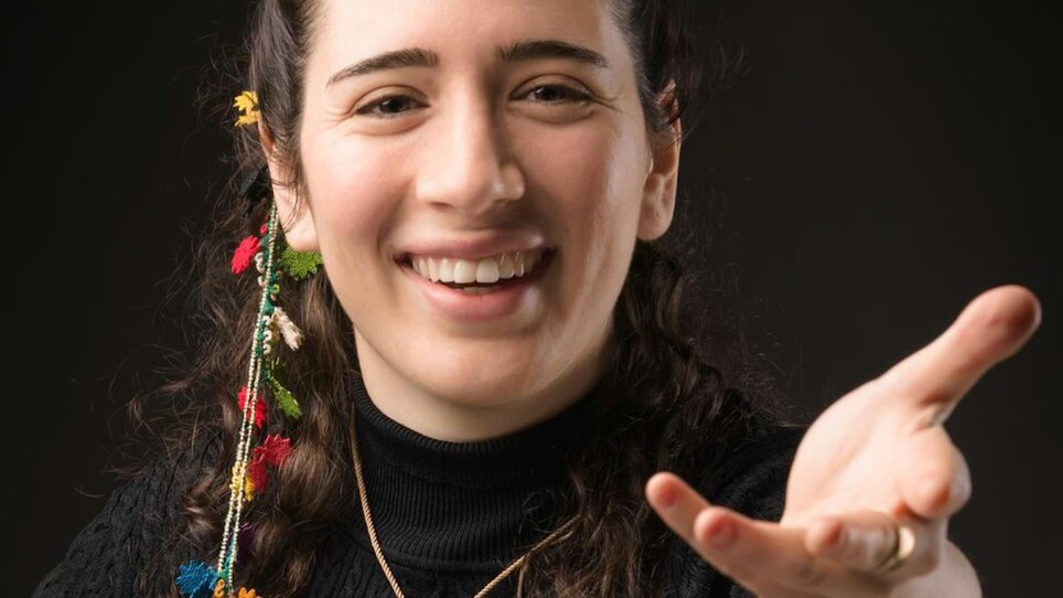 Ritratto di Nil Venditti, che indossa un top nero e ha dei fiori tra i capelli. | © Alessandro Bertani