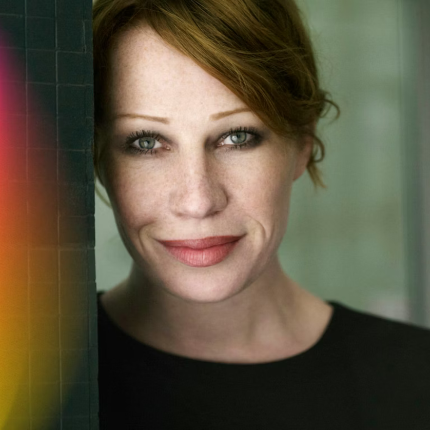 A portrait of Birgit Minichmayr leaning against a wall. | © Christian Schoppe