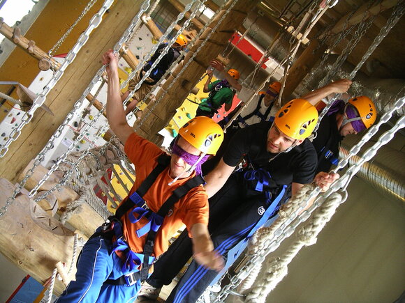 Group participants climbing in a high rope course.