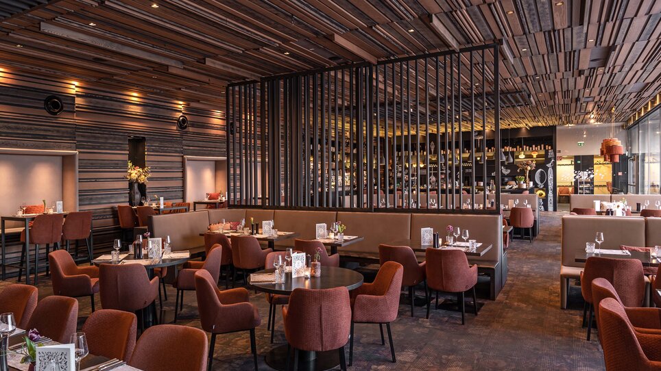 An elegant restaurant design with cozy tables and modern elements. | © Aiola im Schloss