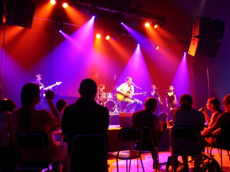 A band performs live on stage at Dom im Berg with colorful lights. | © Graz Tourismus - Harry Schiffer