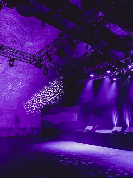 Flexible event space featuring technical infrastructure and purple lighting | © Lupi Spuma