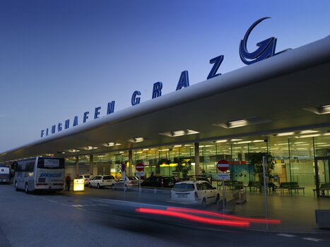 Graz Airport showcasing modern architecture, illuminated during dusk. | © Graz Tourismus - Harry Schiffer