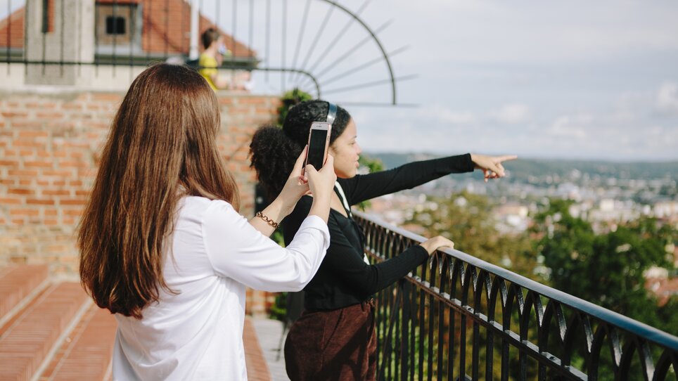 Two women stand at the railing looking at the city of Graz. | © Sebastian Reiser