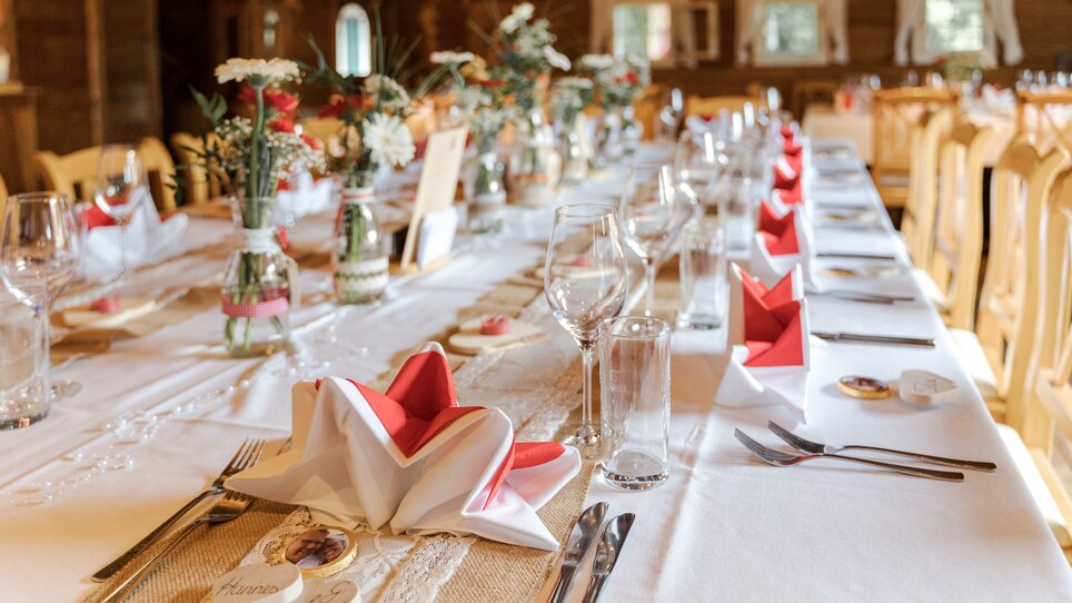 Festlich gedeckter Tisch in der Almhütte Graz mit Blumen und Servietten. | © I AM Hotels