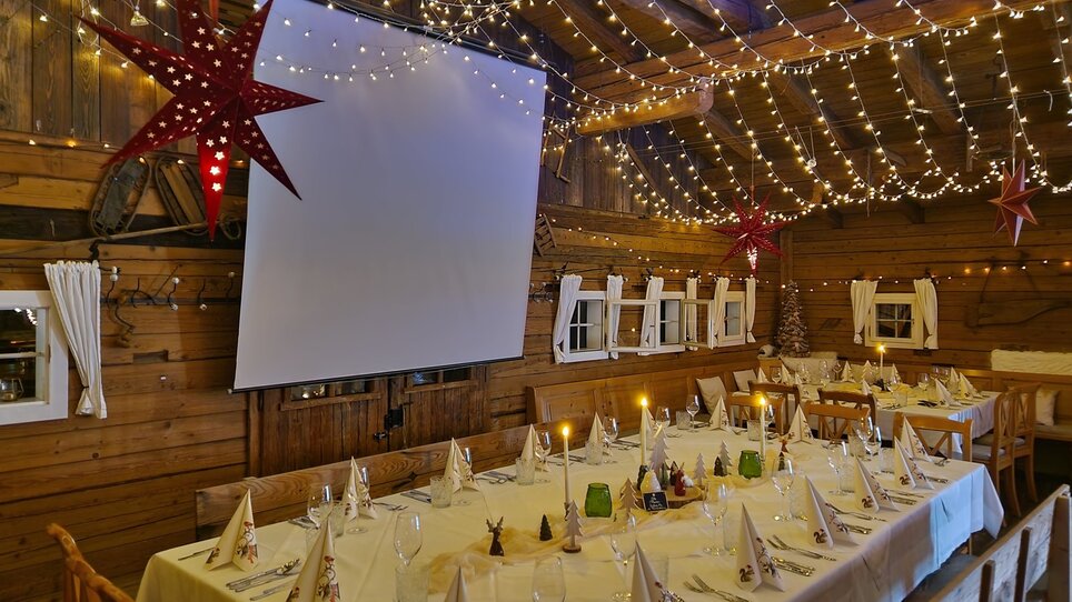 Ein festlich gedeckter Tisch in der Almhütte Graz mit Beleuchtung. | © I AM Hotels
