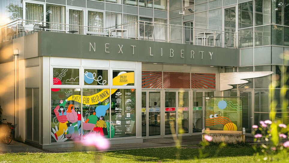 Next Liberty features modern architecture with large windows and colorful graphics. The venue provides a bright atmosphere for conferences and networking. | © Stella