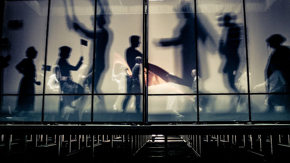 People move in Next Liberty, featuring modern architecture with large windows and an open space feel. Lighting creates a dynamic atmosphere for conferences and networking. | © Lupi Spuma