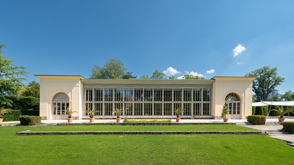 Die Orangerie im Burggarten in Graz umgeben von Grünflächen und Sträuchern. | © Land Steiermark - Melanie Laimer