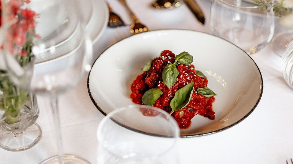 Eine Schüssel mit frischen Himbeeren und Basilikum auf einem Tisch im Palais St. Georg. | © Palais St. Georg