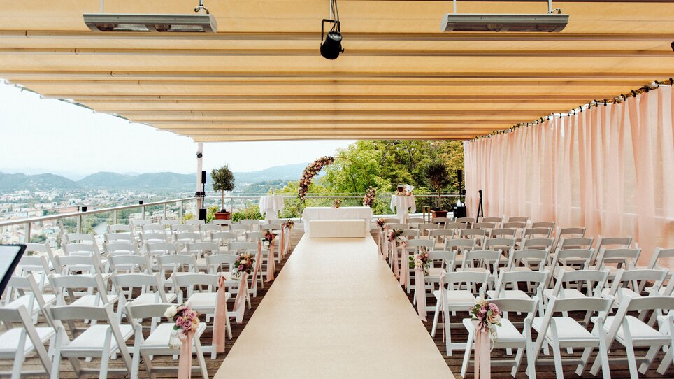 The venue features picturesque views with elegant seating and natural light on the terrace of SKYBAR GRAZ. | © Restaurant SCHLOSSBERG - Kyrillos Mikhail