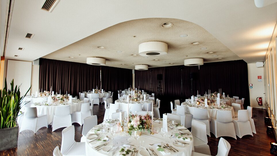 The Restaurant SCHLOSSBERG features a bright, modern ambiance with large windows and stylish tables. The space is versatile for meetings and conferences. | © Restaurant SCHLOSSBERG - Kyrillos Mikhail