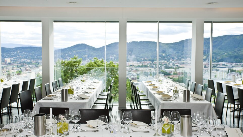 The Restaurant SCHLOSSBERG features an elegant atmosphere with a large window front overlooking Graz. The room is modernly furnished, ideal for meetings and business events. | © Restaurant SCHLOSSBERG