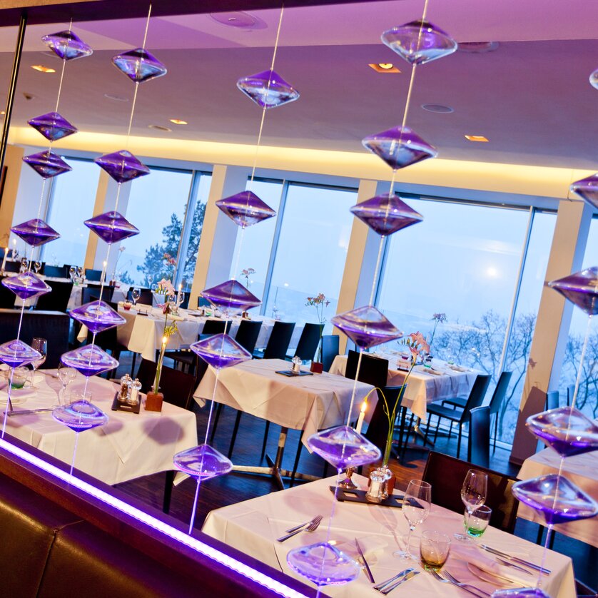 Elegantes Restaurant SCHLOSSBERG mit modernem Design, großen Fenstern, stilvoll gedeckten Tischen und flexibler Raumnutzung. Ideal für Veranstaltungen und Business-Meetings. | © Restaurant SCHLOSSBERG