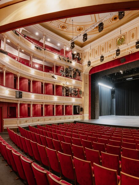 View of the elegant theater interior featuring red velvet seating. | © Lex Karelly