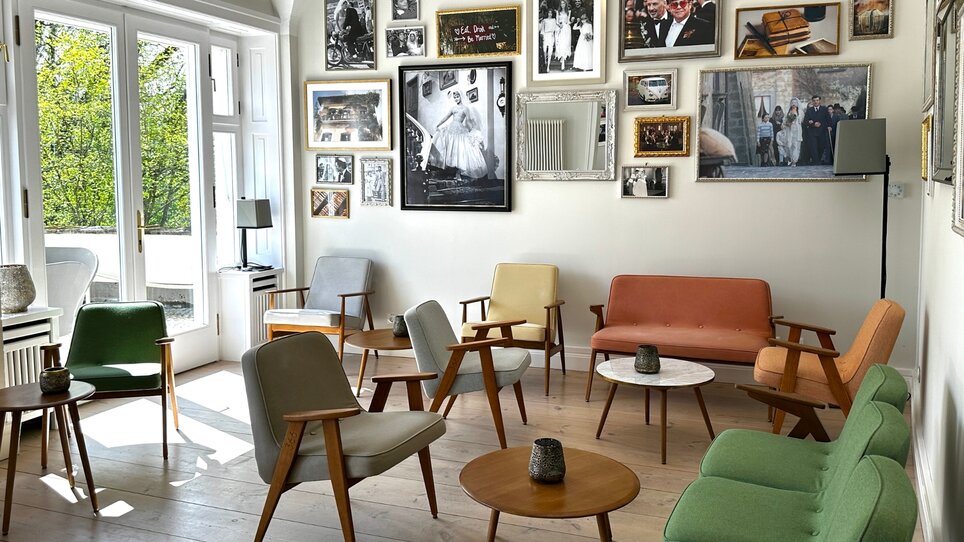 An inviting room with seating and photo walls. | © Schloss Vasoldsberg