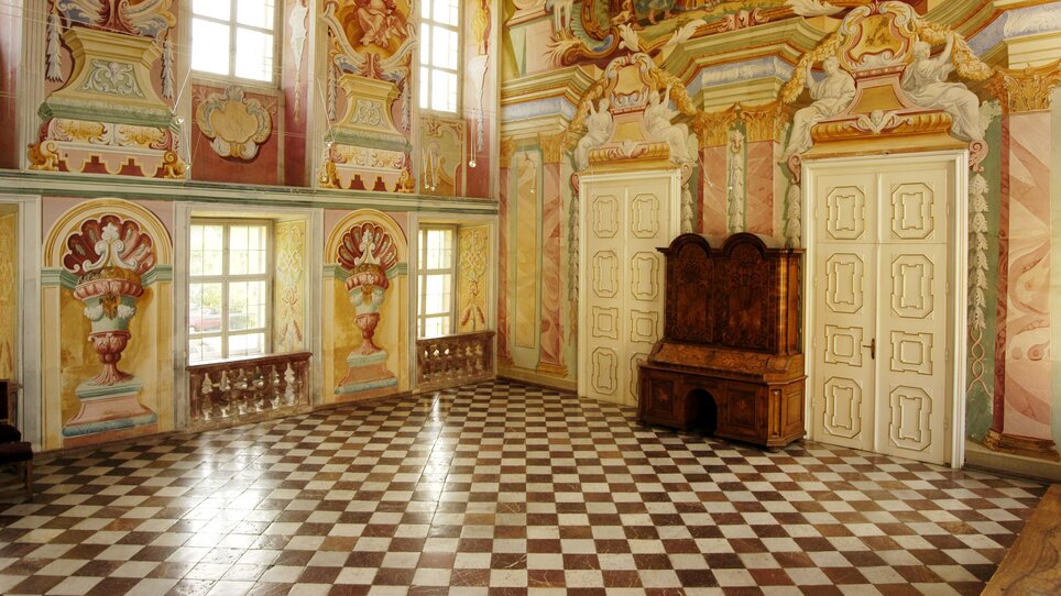 Der prachtvolle Raum in Stift Rein verfügt über hohe Decken, reich verzierte Wände, große Fenster und einen eleganten Boden. Ideal für Veranstaltungen.