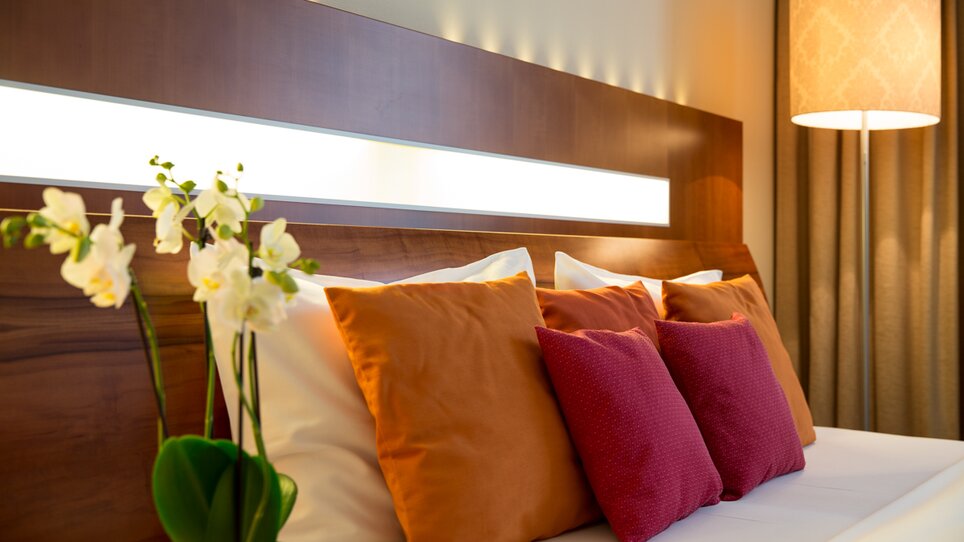 Modernes Zimmer mit bunten Kissen und Orchideen im Hotel Europa Graz. | © Austria Trend Hotel Europa Graz