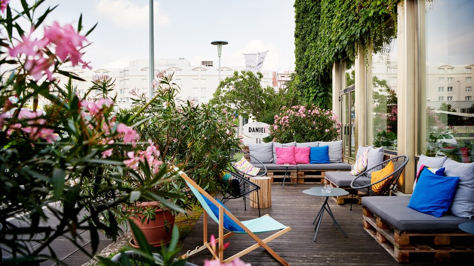 Ein einladender Außenbereich des Hotel Daniel Graz mit bunten Kissen und Pflanzen. | © Florian Weitzer Hotels & Restaurants