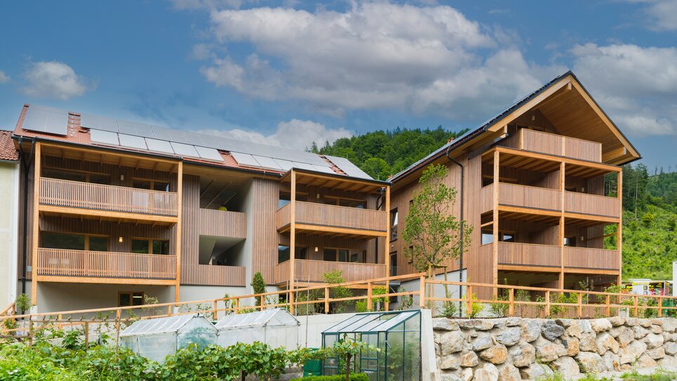 Helle, moderne Wohngebäude mit Holzverkleidung und angrenzendem Garten bei der Genusspension Herti. | © Grossauer