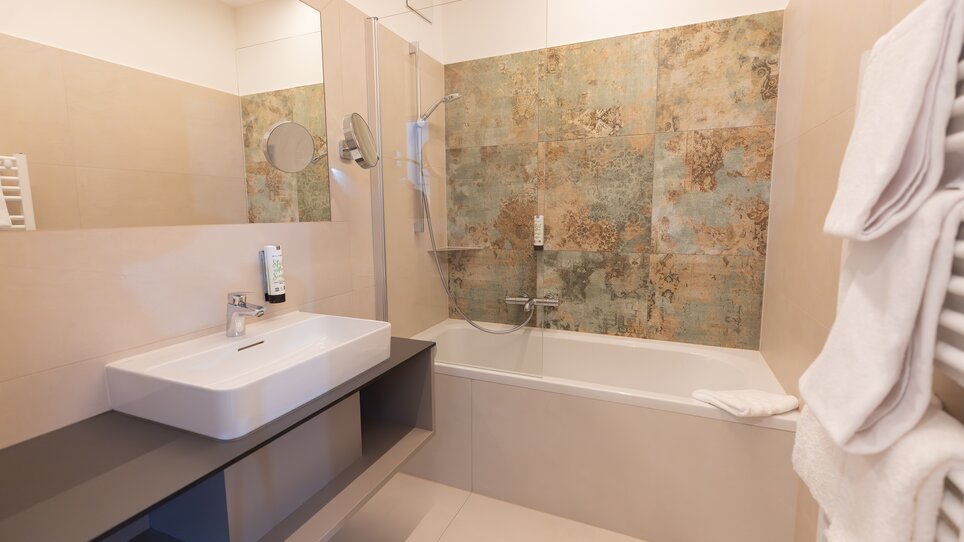 Elegant bathroom featuring sink and bathtub at the Hotel Gollner. | © Hotel Gollner